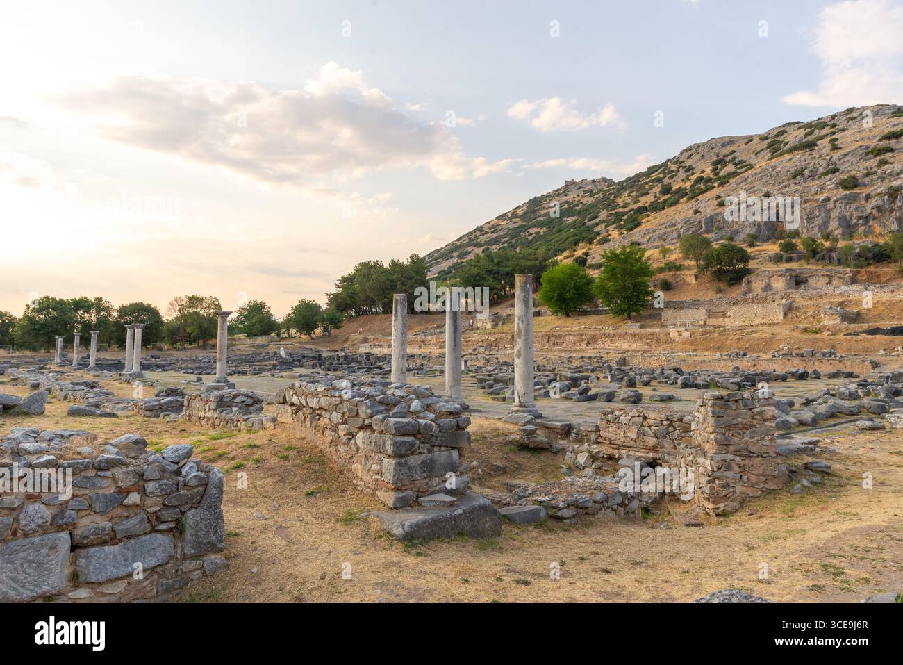 Stehende Säulen und Steinmauern des antiken Forums in Philippi mit dem akropolis-Hügel als malerischer Kulisse Stockfoto