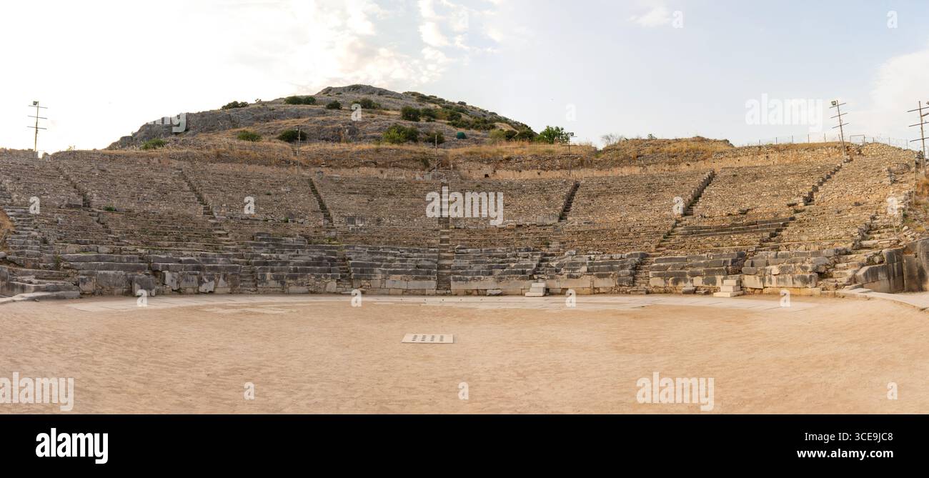 Panoramablick von der Arena des römischen Theaters in Philippi mit Sitzplätzen aus Stein und akropolis-Hügel dahinter Stockfoto