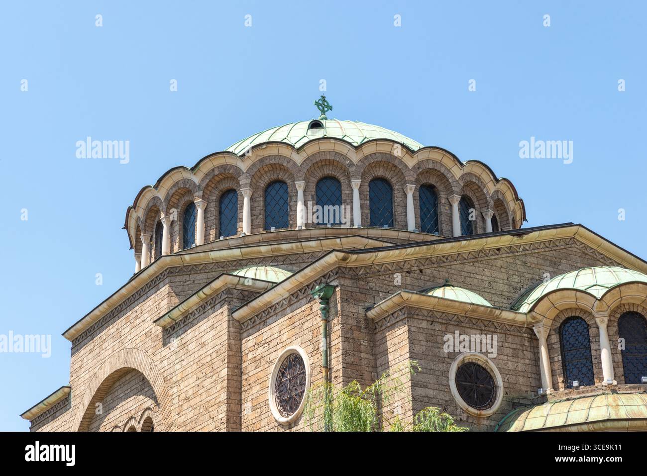 Nahaufnahme der Kuppel und der bogenförmigen Fenster der St. Nedelya Kirche in Sofia mit detailliertem Mauerwerk und grünem Kupferdach Stockfoto