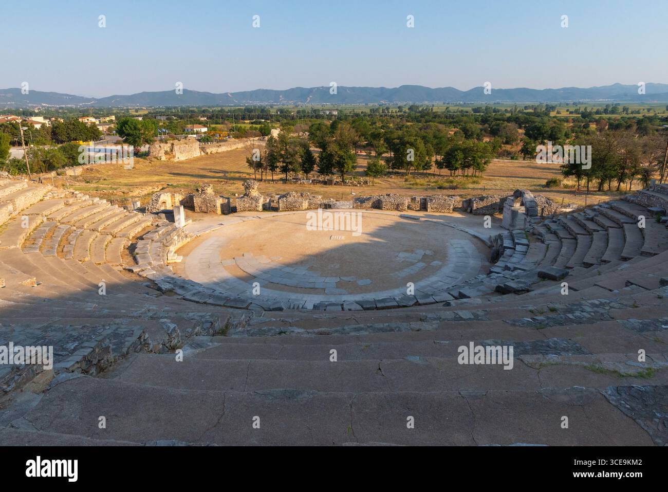 Römisches Theater von Philippi mit Steinarena und Stufensitzen, in den Hügel eingebaut und von einem malerischen ländlichen Panorama eingerahmt Stockfoto