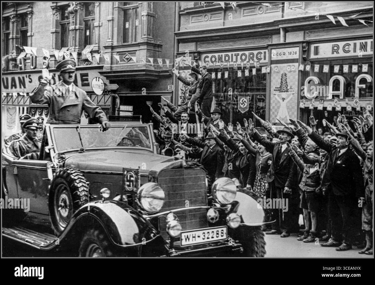 SUDETENLAND HITLER 1. Oktober 1938 Adolf Hitler (1889–1945) wird mit dem Heil-Hitler-Nazi-Gruß begrüßt, als er eine Autokasse durch das Sudetenland führt, kurz nachdem die Region nach dem Münchner Abkommen von Nazi-Deutschland annektiert wurde. Der Besuch markierte die Einverleibung des Sudetenlandes in das Dritte Reich, gefeiert von lokalen Unterstützern und inszeniert als hochkarätiges Propagandaevent, um die deutsche Macht und Einheit in dem neu erworbenen Territorium zu demonstrieren.“ Stockfoto SUDETENLAND HITLER 1. Oktober 1938 Adolf Hitler (1889–1945) wird mit dem Heil-Hitler-Nazi-Gruß begrüßt, als er eine Autokasse durch das Sudetenland führt, kurz nachdem die Region nach dem Münchner Abkommen von Nazi-Deutschland annektiert wurde. Der Besuch markierte die Einverleibung des Sudetenlandes in das Dritte Reich, gefeiert von lokalen Unterstützern und inszeniert als hochkarätiges Propagandaevent, um die deutsche Macht und Einheit in dem neu erworbenen Territorium zu demonstrieren.“ Stockfoto
