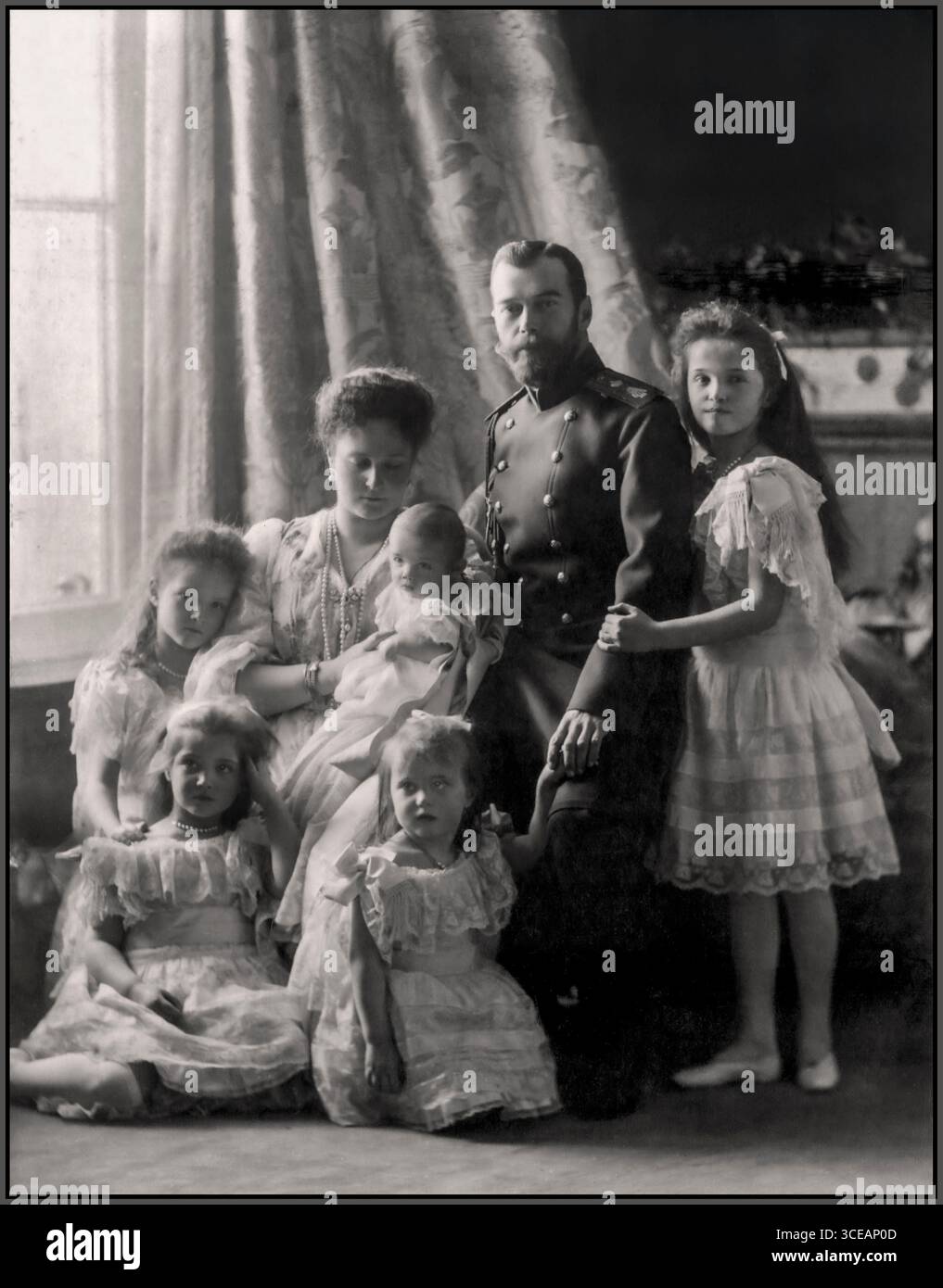Kaiser Nikolaus II. Von Russland mit Kaiserin Alexandra Feodorowna und ihren Kindern, Foto anlässlich der Taufe von Zarewitsch Alexej Nikolajewitsch, um 1904. Das Foto markiert die Feier der Geburt und Taufe des lang erwarteten Erben der Romanov-Dynastie. Abgebildet sind Nikolaus II., Alexandra und ihre Töchter, die Großherzoginnen Olga, Tatiana und Maria. Die Taufe Alexej war ein großes dynastisches Ereignis im Kaiserlichen Russland, das mit einer großen Zeremonie im Peterhof-Palast in St. Petersburg gefeiert wurde und die Kontinuität der Romanov-Linie symbolisierte. Stockfoto