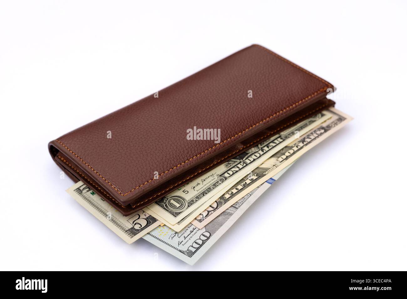 Nahaufnahme einer braunen Ledergeldbörse mit US-Dollar-Scheinen auf weißem Hintergrund. Stockfoto