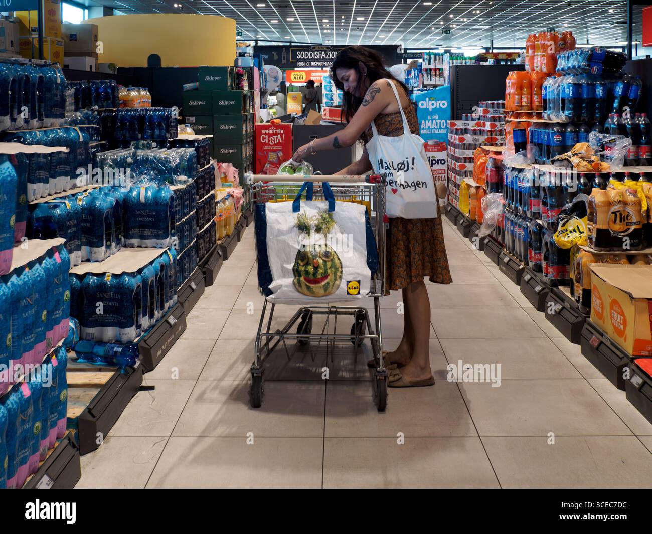Cremona, Italien - 11. August 2025 Kunde wählt erfrischende Getränke aus den Regalen aus, während er Lebensmittel in einem italienischen Discount-Supermarkt kauft Stockfoto