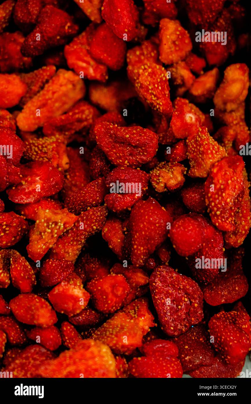 Eine lebendige Nahaufnahme gefriergetrockneter Erdbeeren mit sattem Rot und detaillierter Textur, perfekt für gesundes Naschen oder für Gourmetgerichte Stockfoto