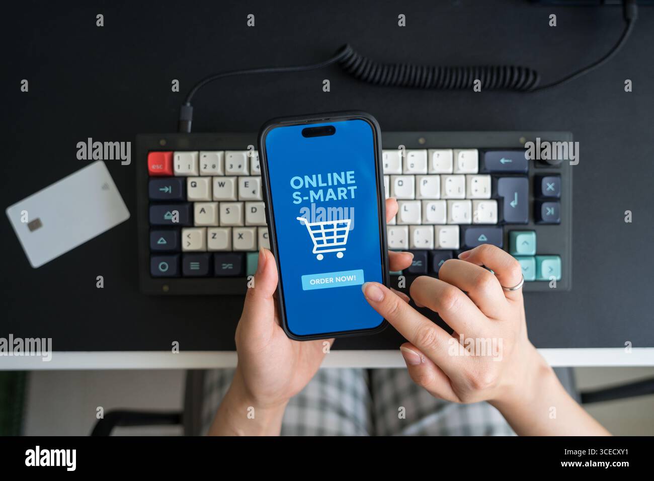 Von oben aus ist eine nicht erkennbare Person, die ein Smartphone nutzt, um zu Hause Lebensmittel online einzukaufen, was den Komfort des E-Commerce in modernem digi unterstreicht Stockfoto