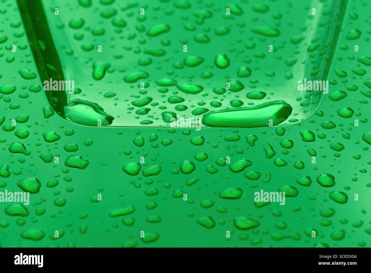 Regentropfen auf glatter grüner metallischer Oberfläche von Industrieobjekten, Wetter- und Klimakonzept, selektiver Fokus Stockfoto