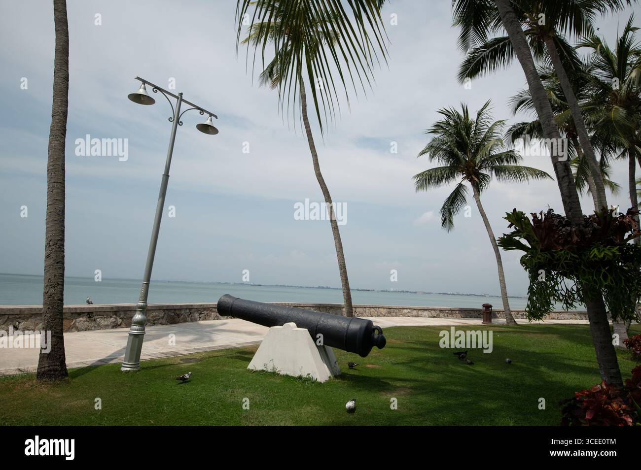 Eine Kanone in den Gärten, die auf das Meer zeigt, vor dem Eastern & Oriental (E&O) Hotel in Goerge Town, Hauptstadt Penang in Malaysia, dem C Stockfoto