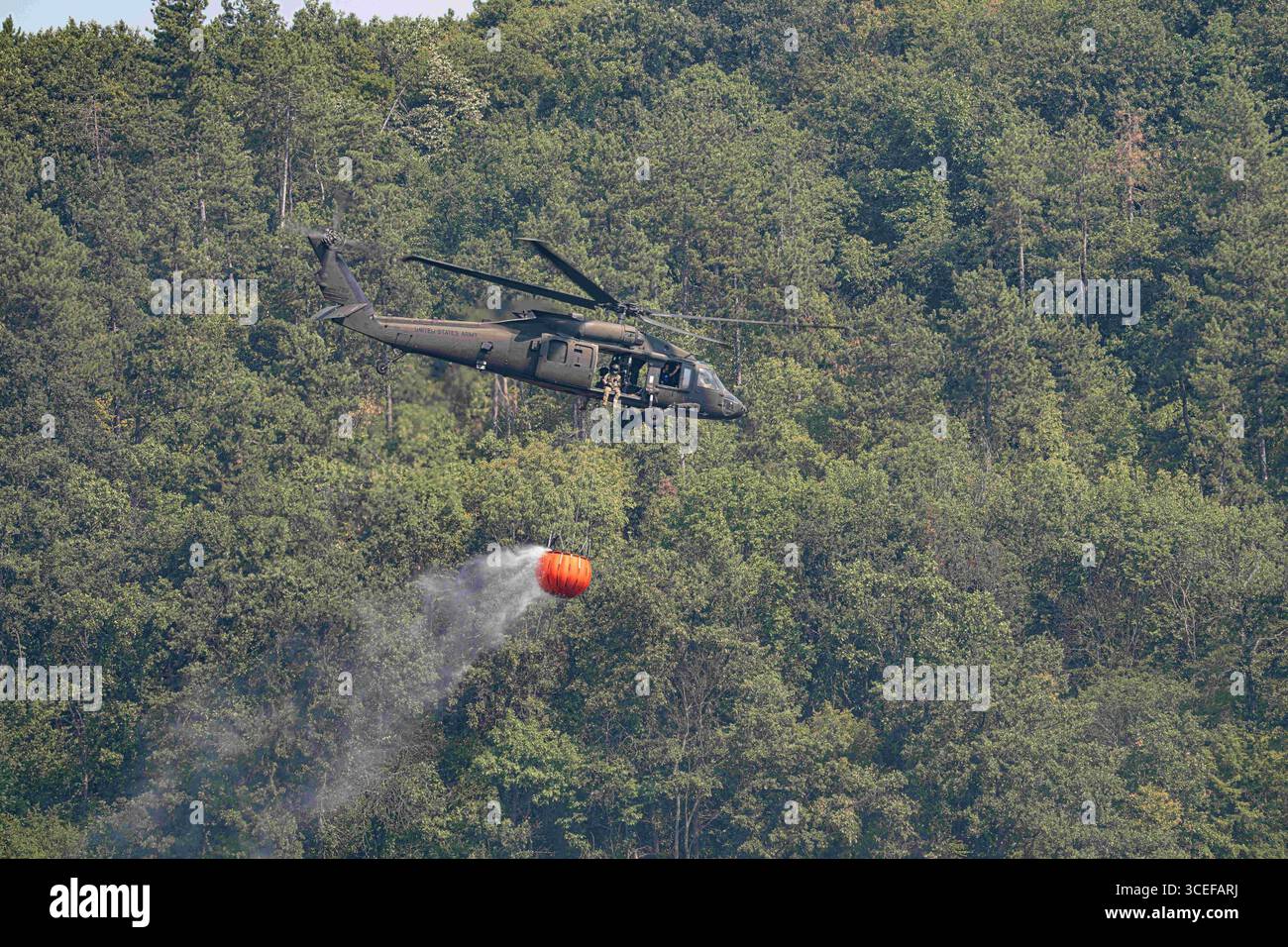 Bulgarien. August 2025. Soldaten der US-Armee, die dem 3. Sturmhubschrauber-Bataillon, 501. Aviation Regiment, 1. Panzerdivision Kampfflugbrigade, Task Force Iron, zugewiesen sind, nutzen einen UH-60 Black Hawk Hubschrauber, um Luftfeuer mit einem Bambi Eimer in der Nähe des Novo Selo Training Area im August durchzuführen. 11, 2025. Die rasche Luftreaktion unterstützt unsere bulgarischen Partner bei der Eindämmung von Waldbränden und der Verhinderung weiterer Schäden in der Region. (Credit Image: © US Army/ZUMA Press Wire) NUR REDAKTIONELLE VERWENDUNG! Nicht für kommerzielle ZWECKE! Stockfoto