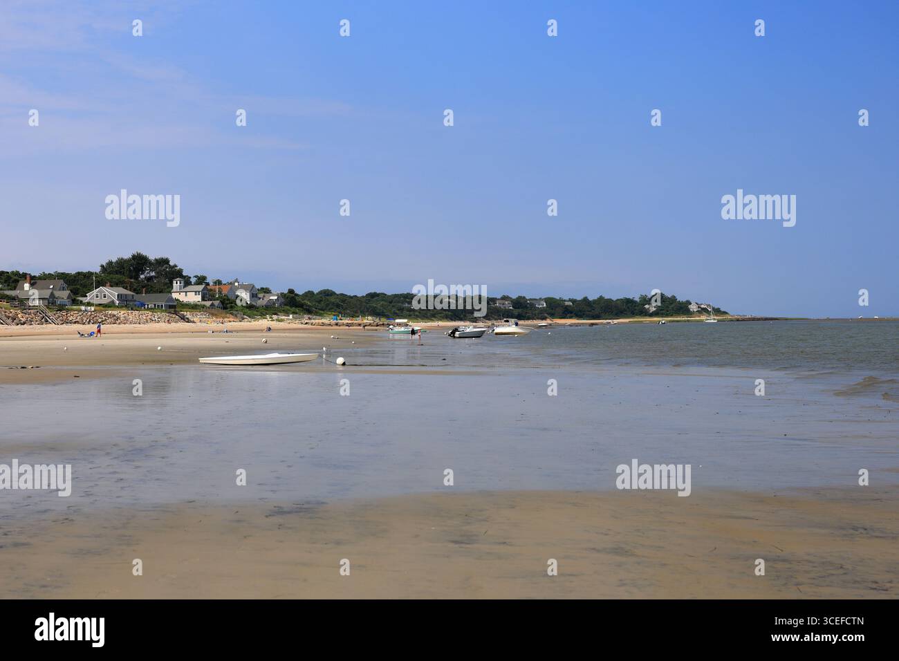 Hyannis, MA, USA - 31. Juli 2025 - Menschen, die bei Ebbe durch die Sandflächen der Cape Cod Bay wandern Stockfoto