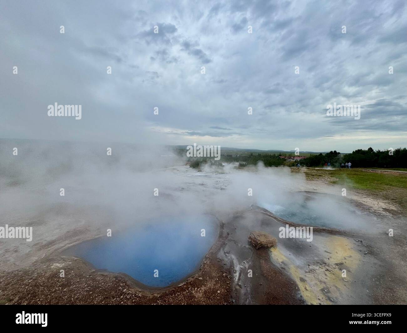 Blesi Thermalquelle hat 2 miteinander verbundene Pools. Der nördliche Pool hat ein hellblaues milchiges Aussehen. Der südliche Pool ist klar blaues Wasser. - Smartphone-aufgenommenes Stockfoto