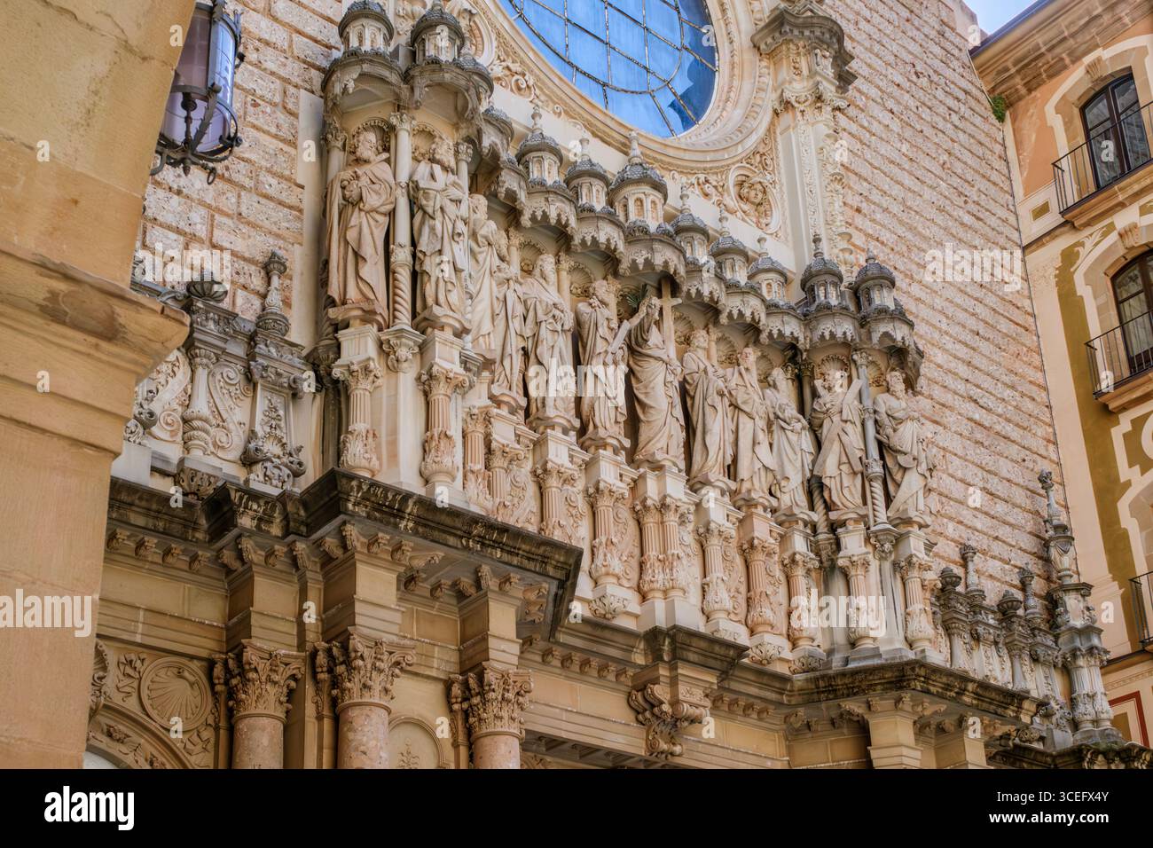 Reich Verzierte, Im Gotischen Stil Erhaltene Fassade Der Basilika Montserrat Mit Geschnitzten Religiösen Statuen Und Rosenfenster. Heilige Architektur, Apostelskulpturen, Pilgerkarten Stockfoto
