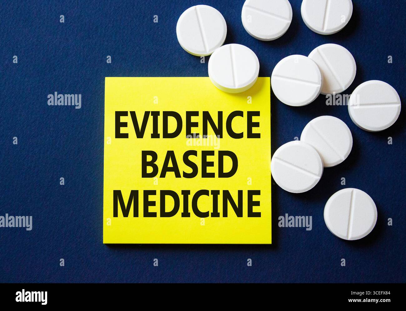 Evidence Based Medicine Symbol. Konzeptwort Evidenzbasierte Medizin auf gelber Note. Wunderschöner tiefblauer Hintergrund mit Pillen. Medizin und Evidenz Stockfoto