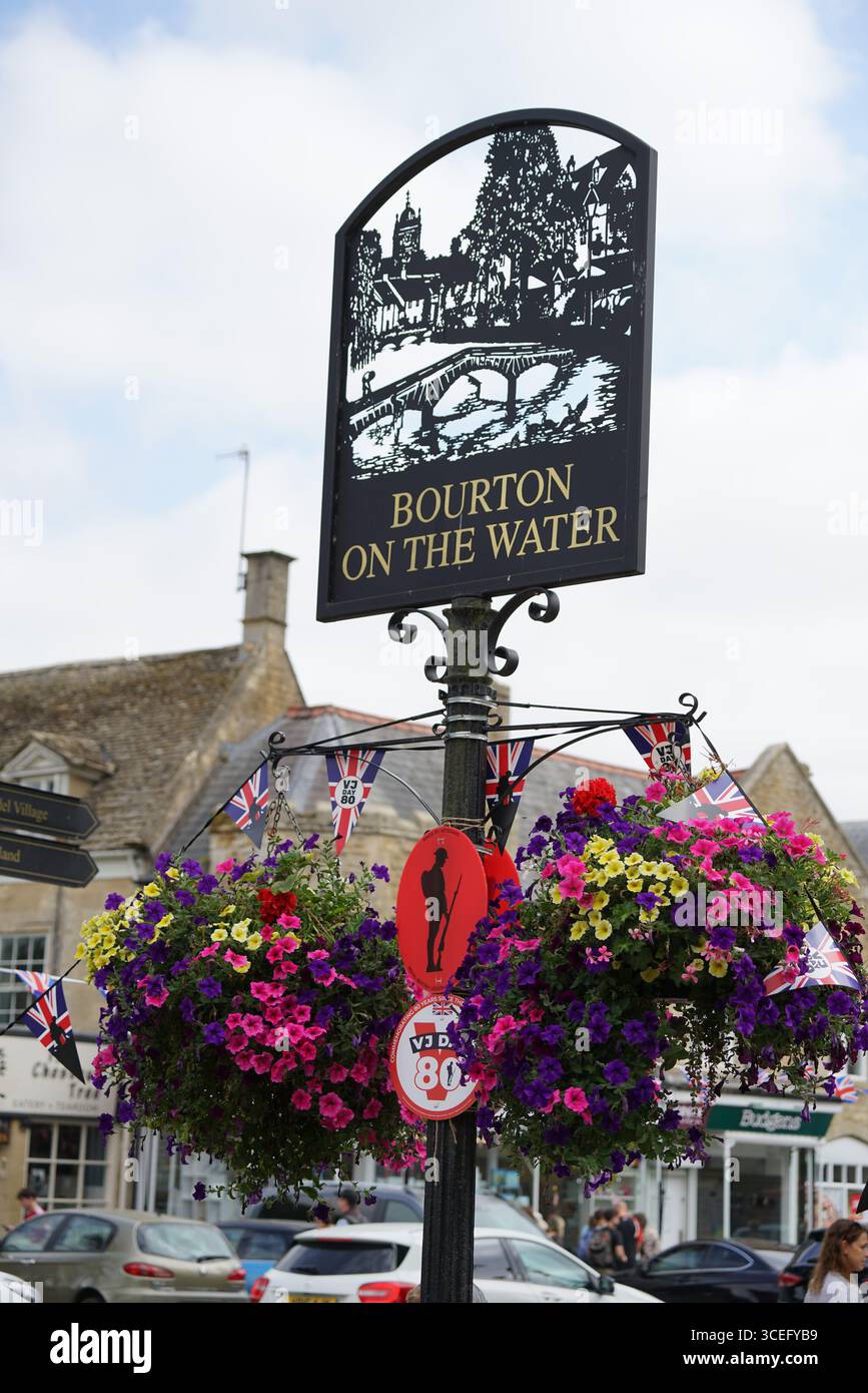 Bezauberndes Straßenschild mit bunten Blumen in Bourton-on-the-Water Village. Bourton-on-the-Water, England Stockfoto