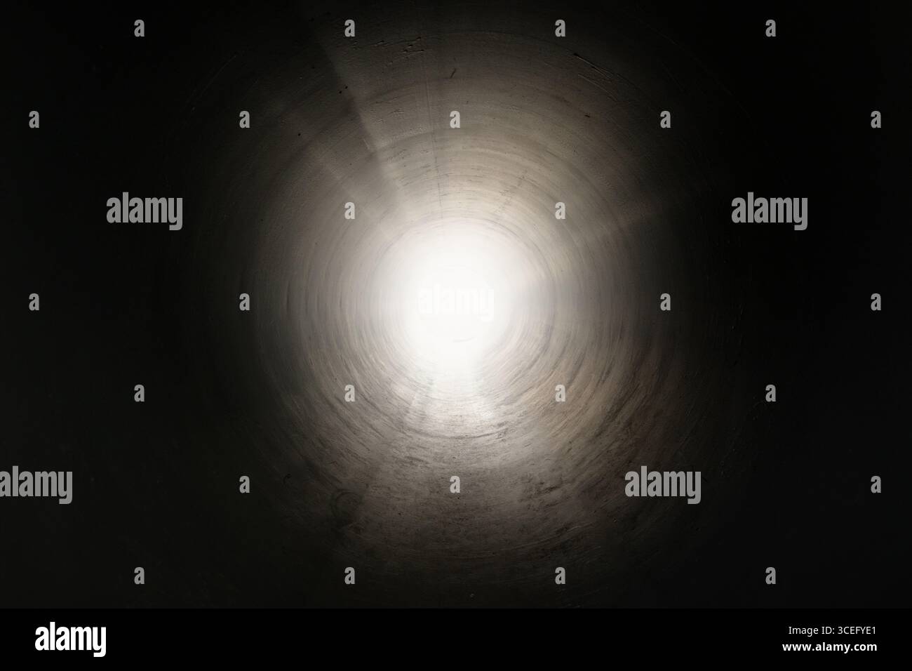Symbolischer Blick aus dem Inneren eines dunklen Tunnels in Richtung fernen Lichts. Konzept von Hoffnung, Transformation, Flucht oder Neuanfang. Metaphorisches und emotionales VI Stockfoto