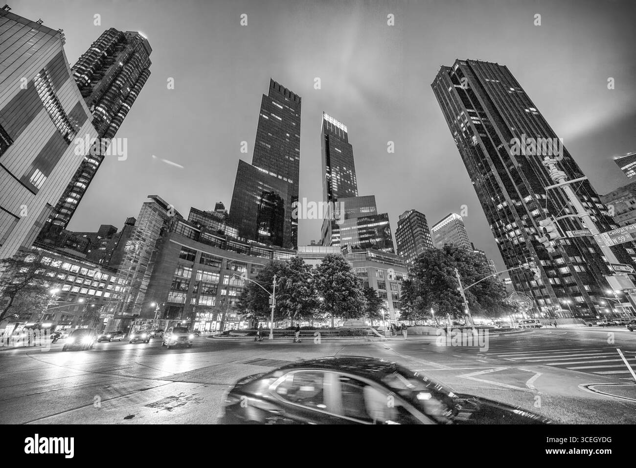 New York City, NY - 14. Juni 2025: Nächtlicher Blick auf den Columbus Circle in NYC mit Stadtlichtern, Bewegungsunschärfen von Autos und urbaner Energie. Stockfoto