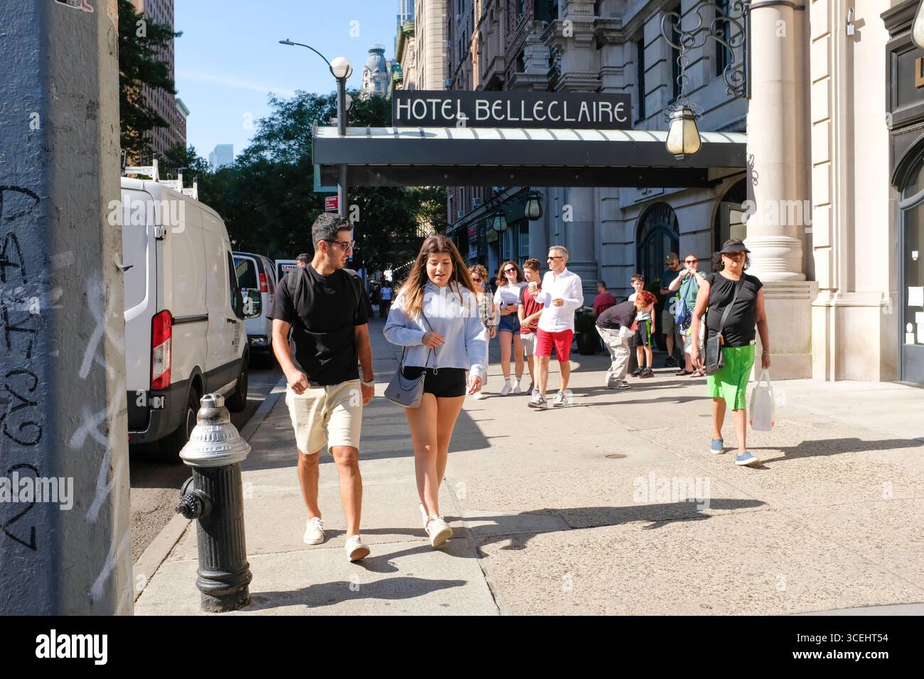 Leute, die in der Sonne in New York spazieren gehen, außerhalb des Hotels Belleclaire. Stockfoto