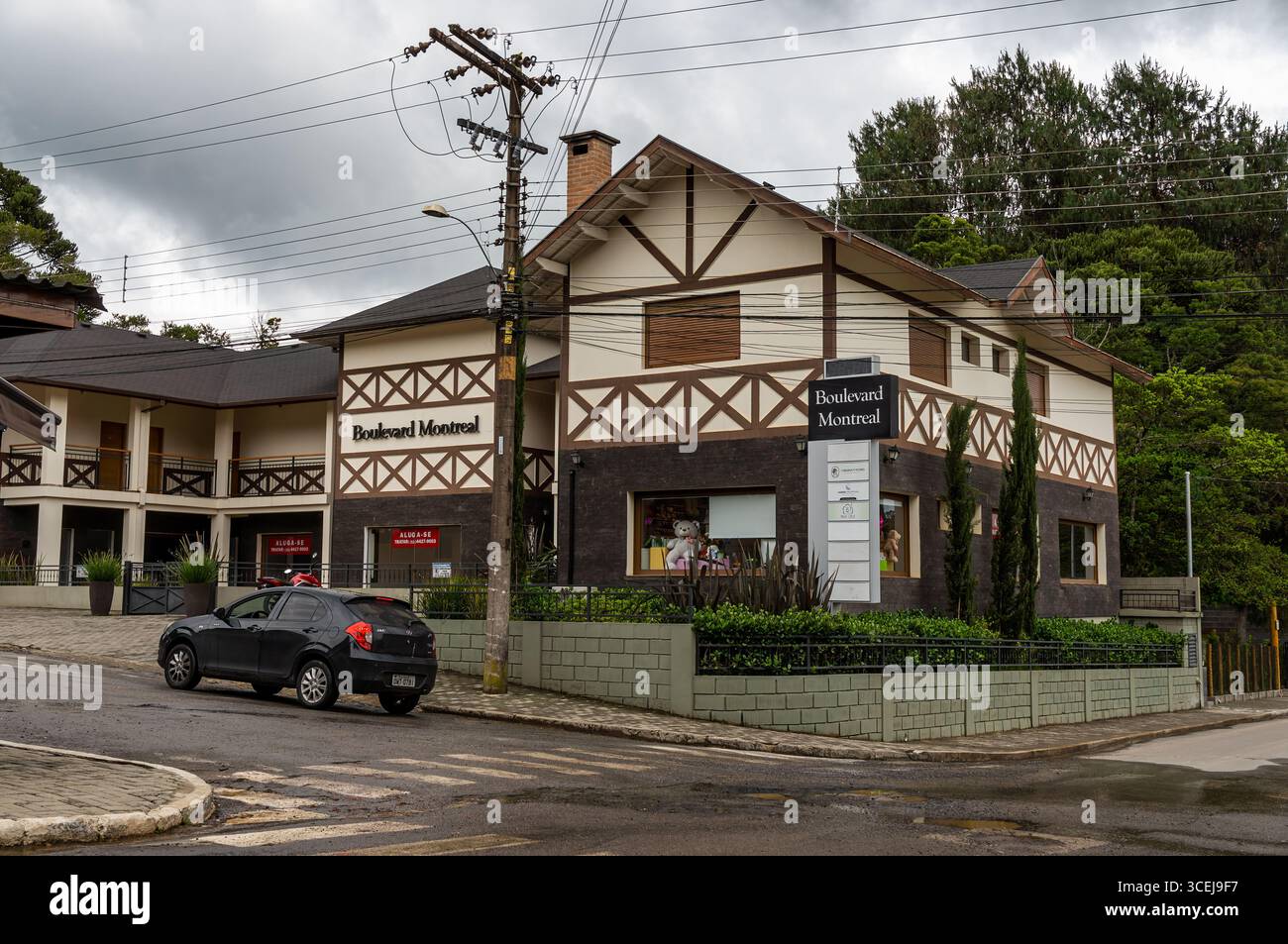 Boulevard Montreal Gebäude mit traditioneller Architektur, einem vorbeifahrenden schwarzen Auto und üppigem Grün unter einem bewölkten Sommernachmittag. Stockfoto