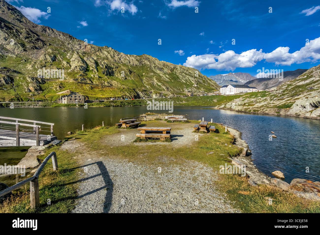 Blick auf den kleinen Alpensee zwischen den Bergen unter blauem Himmel mit weißen Wolken am Gran San Bernardo Bergpass in Italien. Stockfoto