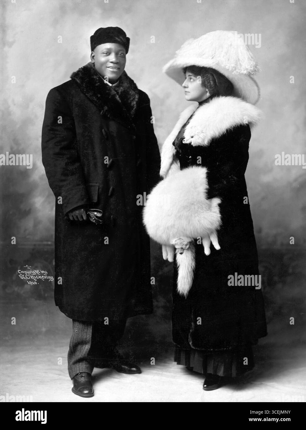 Jack Johnson und seine Frau Etta Duryea, Porträt in voller Länge, stehend, in Wintermänteln, um 1910 Stockfoto