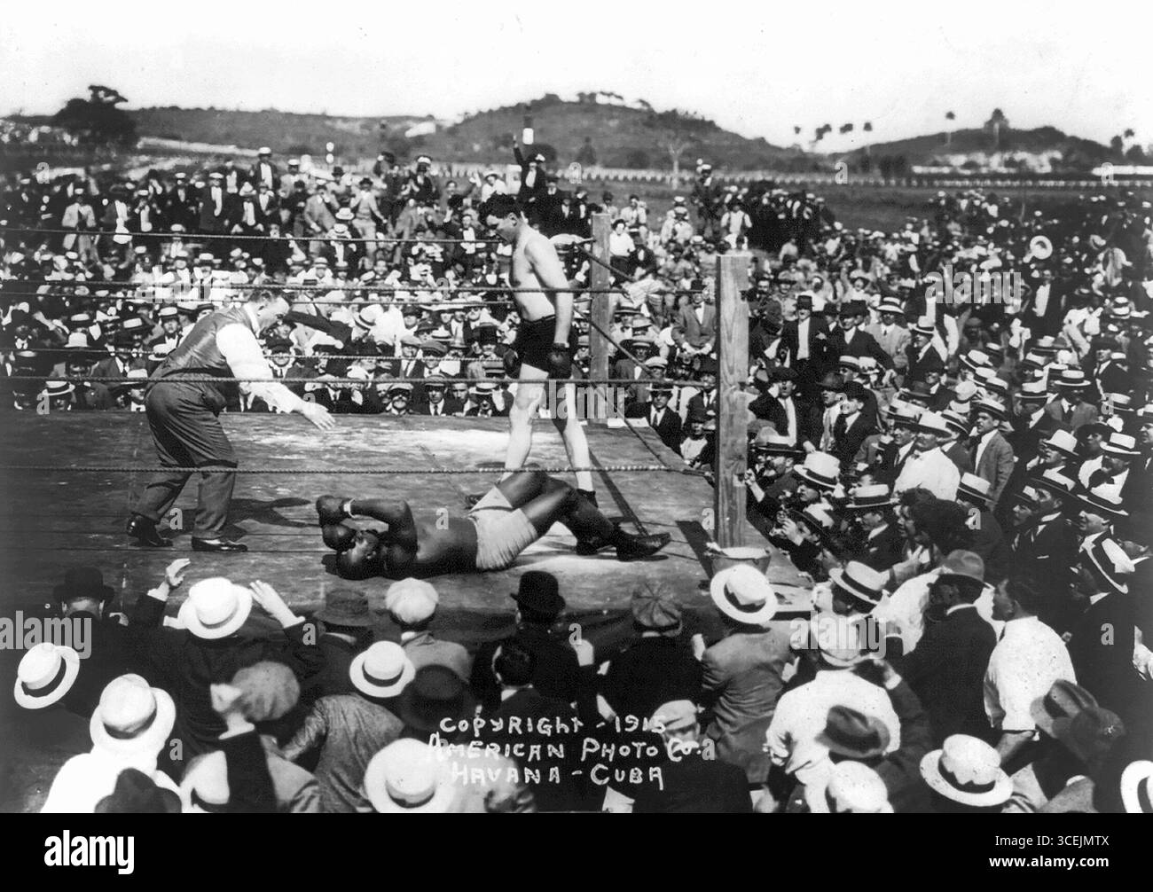Ein Outdoor-Boxkampf mit Jess Willard, der über einem ausgestorbenen Jack Johnson steht und vom Schiedsrichter Havanna Kuba 1915 gezählt wird Stockfoto