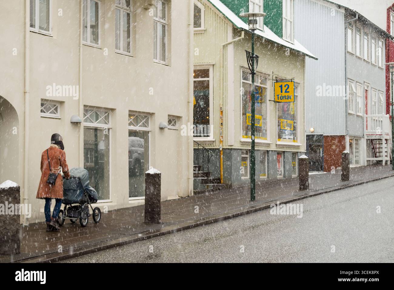 Frau schieben Kinderwagen auf Bürgersteig, Skólavörðustíg, Miðborg, Reykjavík, Island Stockfoto