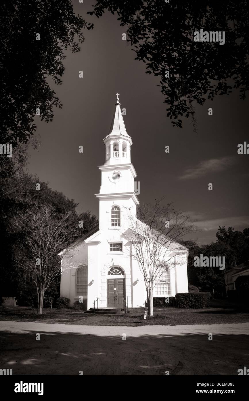 Zeitloser glaube – Ein klassisches Schwarz-weiß-Porträt eines Kirchturms, der sich in den Himmel erhebt. Stockfoto