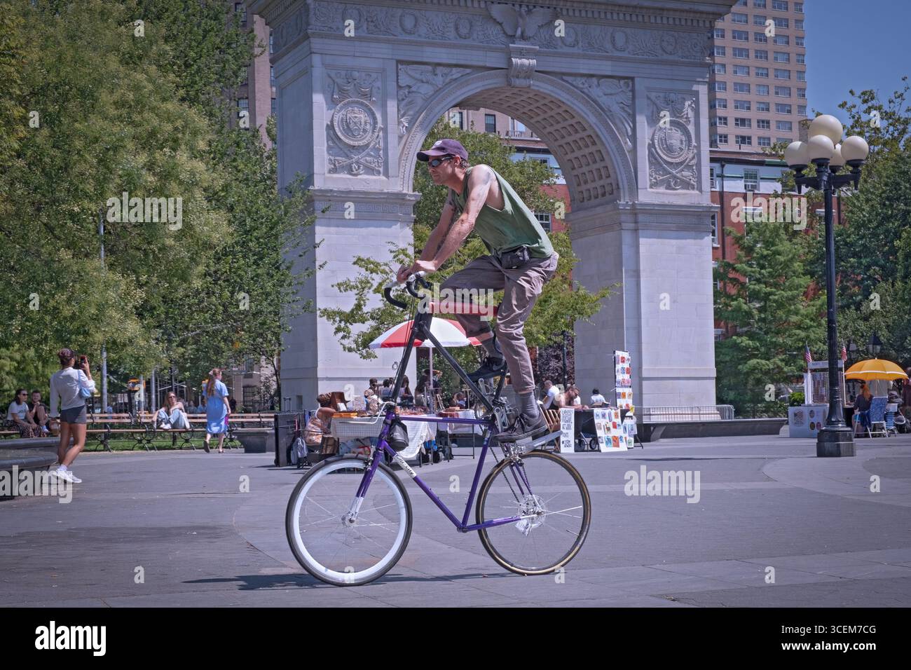 Ein Mann auf einem ungewöhnlich hohen Fahrrad. Im Washington Square Park in Greenwich Villahe, Manhattan, New York. Stockfoto