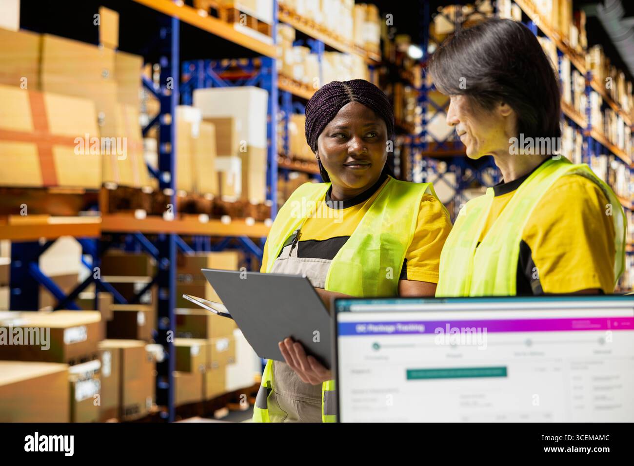 Ein Team aus afroamerikanischen und asiatischen Mitarbeitern überprüft Paketdaten auf einem Tablet und liefert Online-Bestellungen für lokale Marken. Mit Express-Zustelldiensten und internen Abläufen sorgen Sie für eine schnelle Abwicklung. Stockfoto