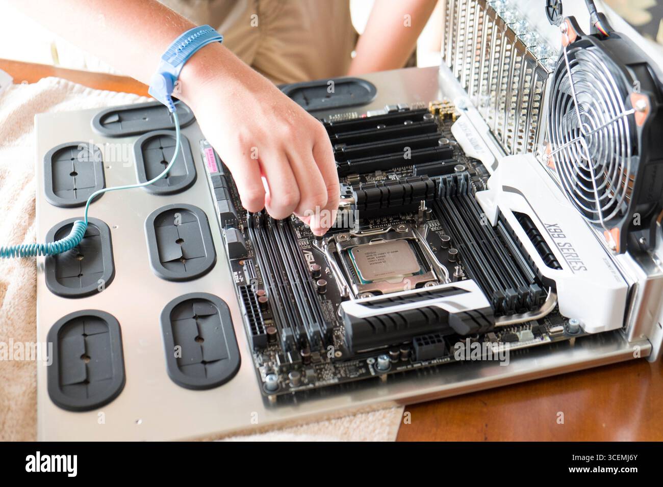 Männlichen Teenager schärferes Vorgehen ein Intel Core i7 - 5930K Haswell-E 6-Core 3,5 GHz LGA 2011-v3 140W Desktop-Prozessor auf einem ASUS X 99 Deluxe motherboard Stockfoto