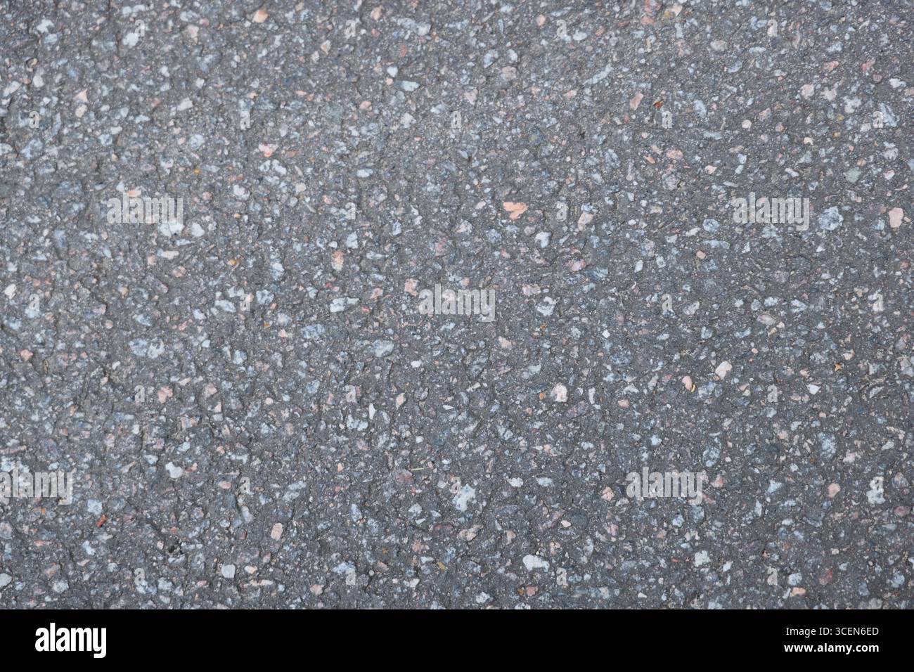 Nahaufnahme einer komplex strukturierten Asphaltoberfläche mit verschiedenen Aggregatkomponenten Stockfoto