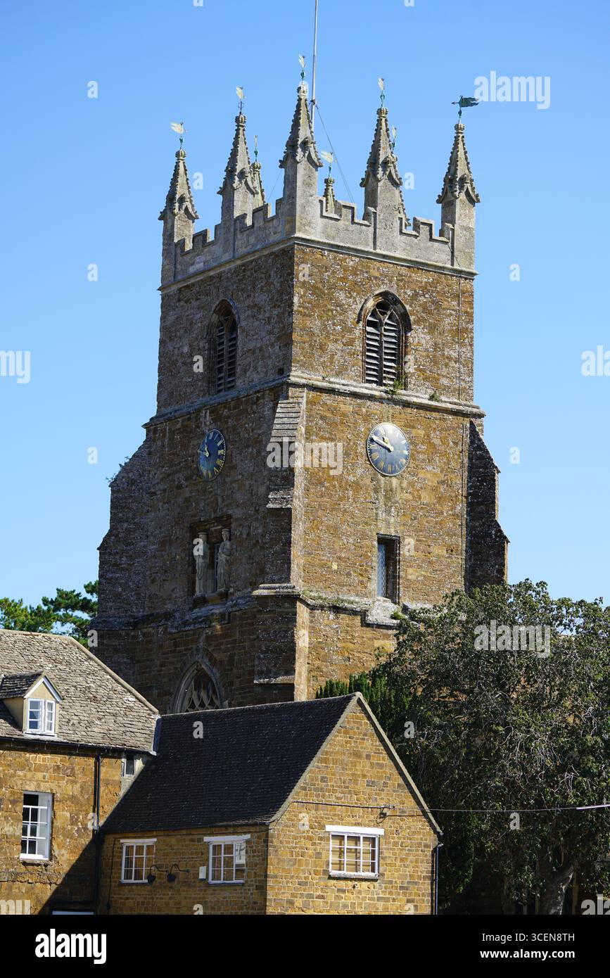 Historischer Steinkirchturm Mit Uhr Unter Klarem Blauem Himmel. Deddington, England Stockfoto
