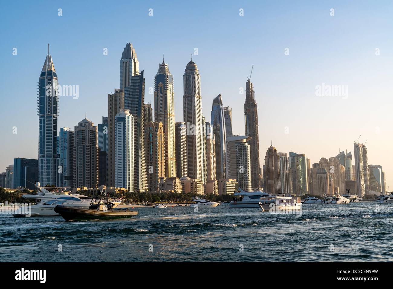 Dubai, Vereinigte Arabische Emirate - 17. März 2023: Wolkenkratzer und Boote an der Küste von Dubai bei Sonnenuntergang Stockfoto