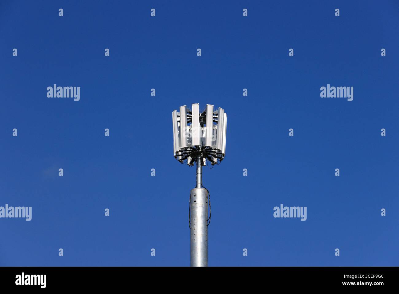 5 g Mobiltelefonmast mit unlackiertem Stahlmonopol und zwölf Antennen-Array, mit blauem Himmel und hellem Sonnenschein in whitefield Greater manchester uk Stockfoto