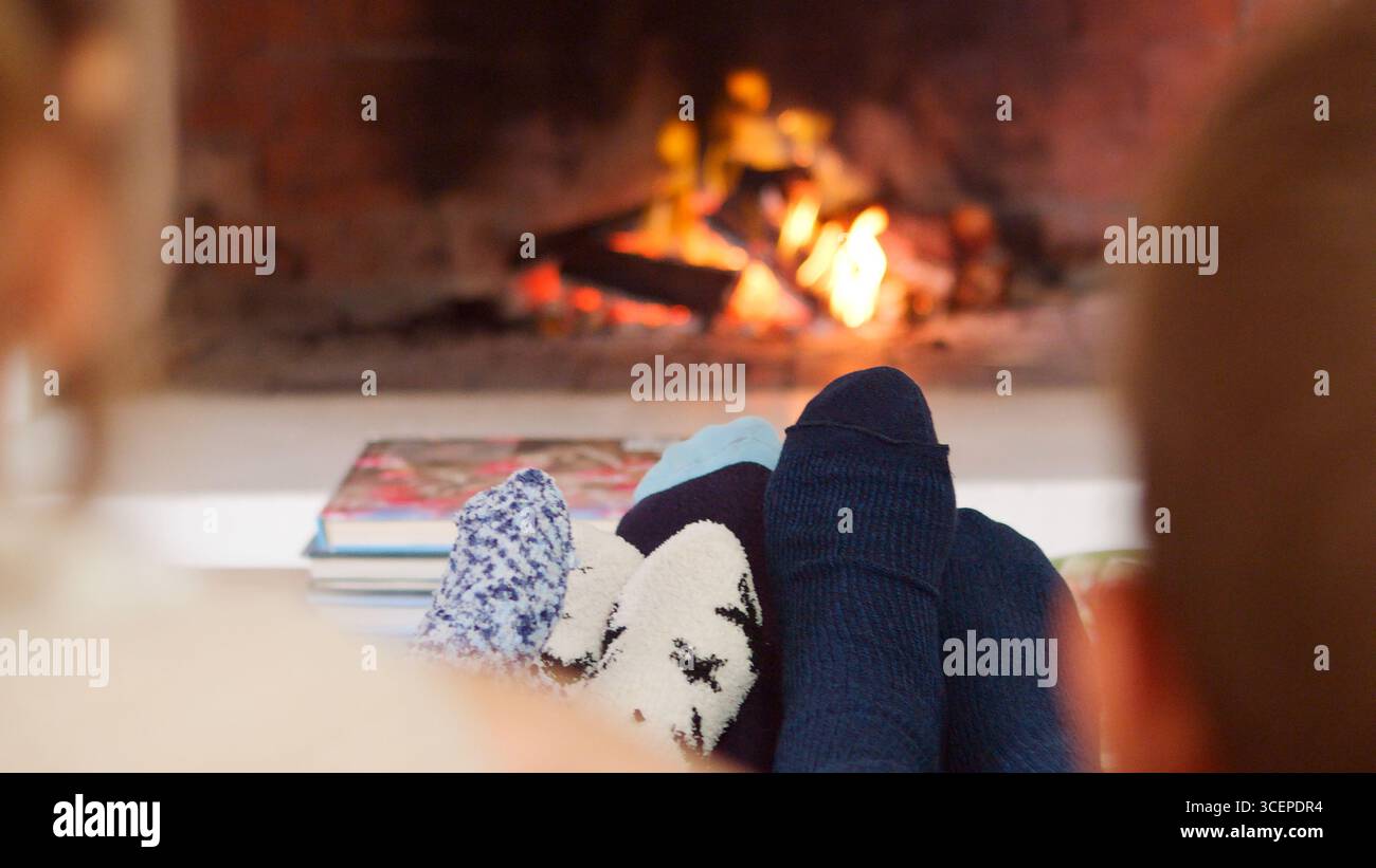 Nahaufnahme Von Family Warming Feet By Open Fire Stockfoto