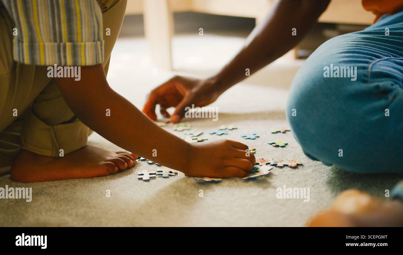 Nahaufnahme Von Eltern Und Kind Zu Hause, Die Puzzle Zusammen Machen Stockfoto