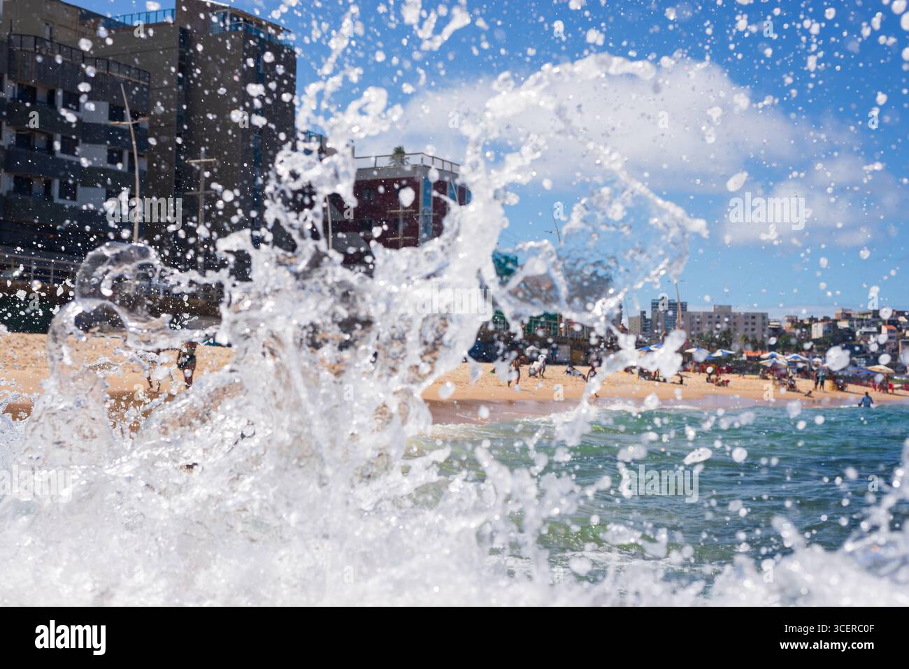 Spritzer einer Strandwelle, die hart gegen einen Zementpfeiler kracht. Wintersaison. Kraft der Natur. Stockfoto