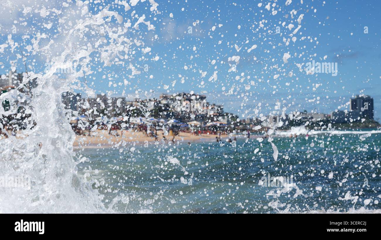 Spritzer einer Strandwelle, die hart gegen einen Zementpfeiler kracht. Wintersaison. Kraft der Natur. Stockfoto