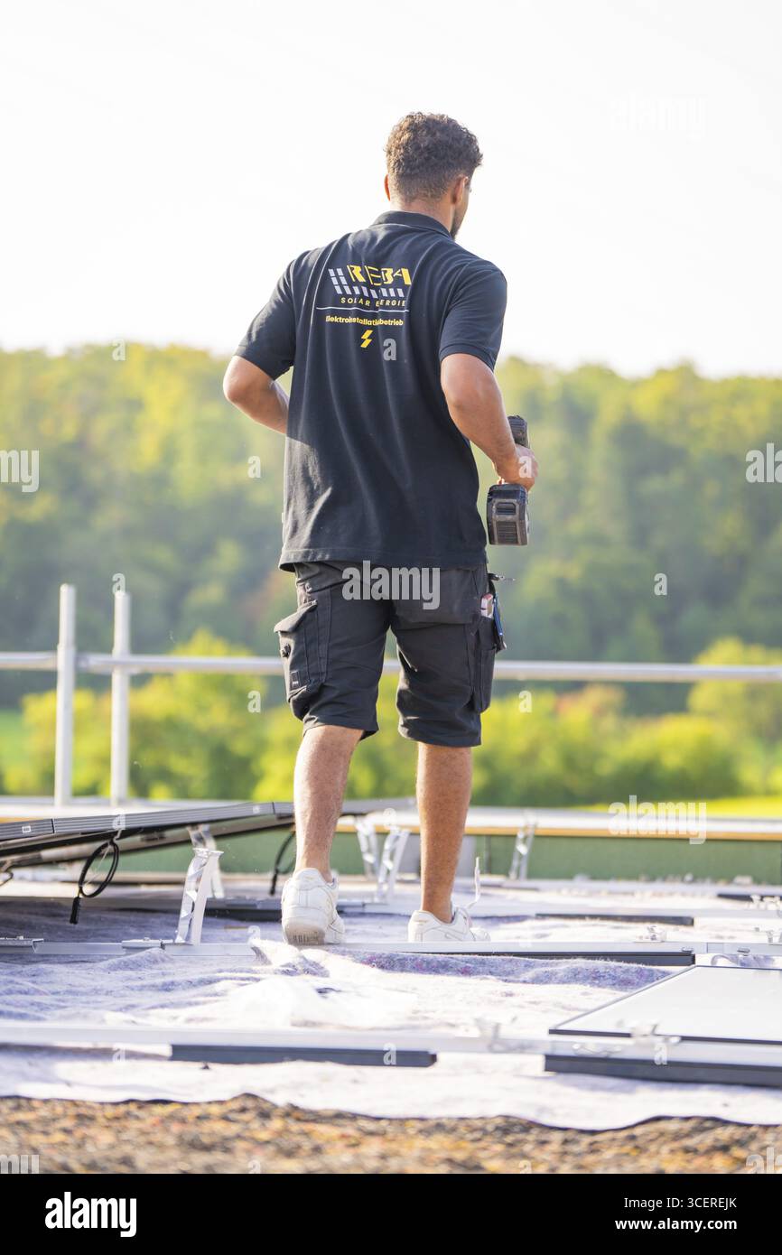 Arbeiter mit Werkzeugen während der Montage auf einem Dach, PV-Installation, gewerbliche Kunden, Neubau, Wiernsheim, Deutschland Stockfoto