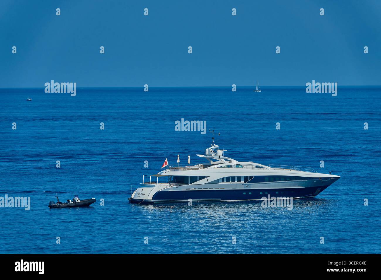 Hashtag Der Luxusyacht, Der Auf Dem Klaren Blauen Ozean Verankert Ist, Mit Einem Tender Nach Osten Gebunden Stockfoto