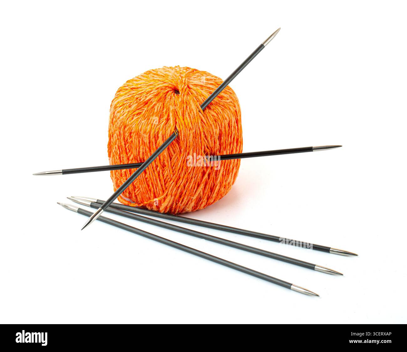 Orangefarbenes Garn und Stricknadeln für warme Kleidung oder Accessoires, isoliert auf weiß Stockfoto