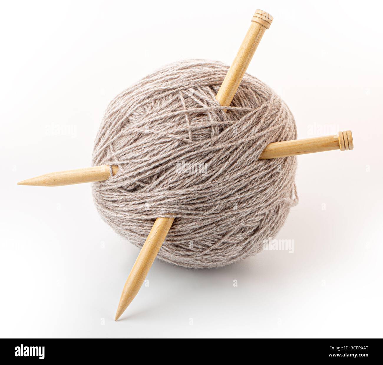 Beigefarbenes Garn und Stricknadeln, bereit für das Bastelprojekt, um gemütliche Textilien zu schaffen Stockfoto
