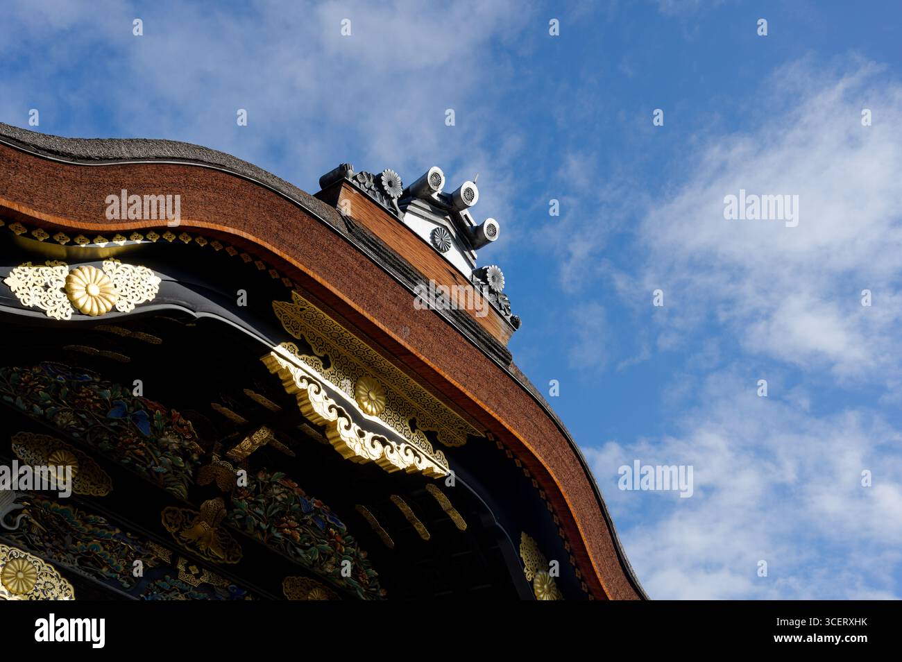 Goldene Details des Karamon-Tordachs auf der Burg Nijo in Kyoto vor einem blauen Himmel Stockfoto