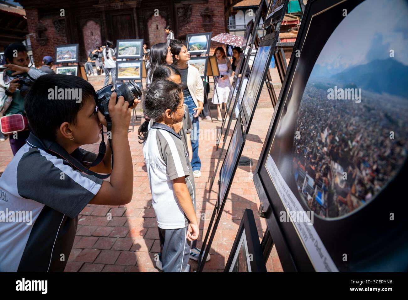 Kathmandu, Nepal. August 2025. Studenten besuchen und machen Fotos bei einer Fotoausstellung, die anlässlich des Weltfotografietages in Kathmandu, Nepal, 19. August 2025 stattfindet. Quelle: Hari Maharjan/Xinhua/Alamy Live News Stockfoto