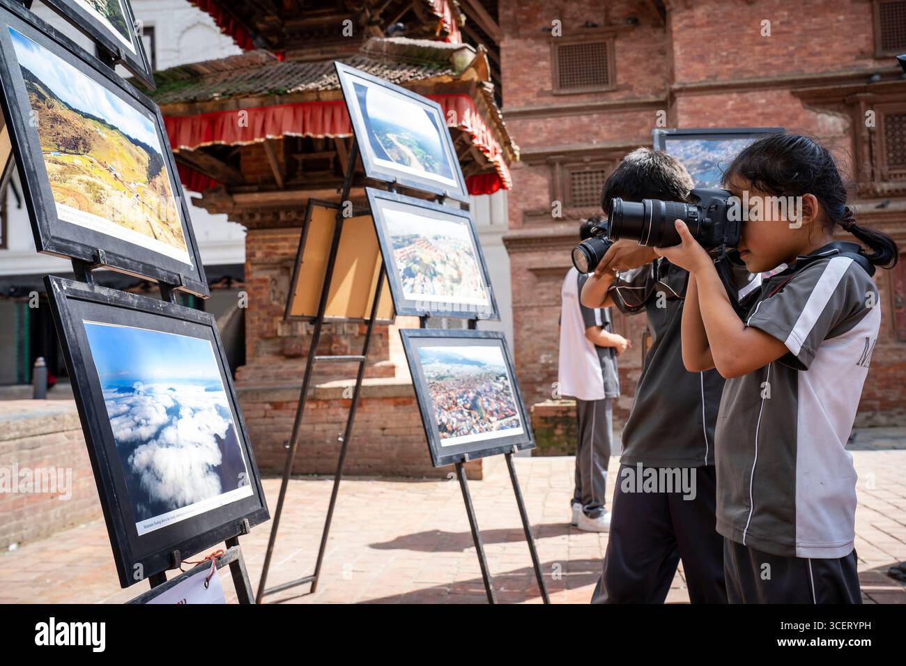 Kathmandu, Nepal. August 2025. Studenten besuchen und machen Fotos bei einer Fotoausstellung, die anlässlich des Weltfotografietages in Kathmandu, Nepal, 19. August 2025 stattfindet. Quelle: Hari Maharjan/Xinhua/Alamy Live News Stockfoto