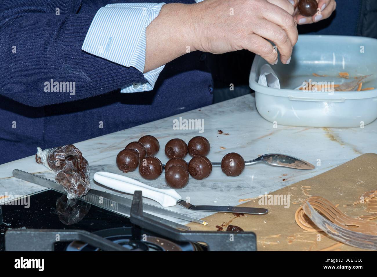 Konditorin füllt Schokoladentrüffel mit Schokoladenganache. Stockfoto