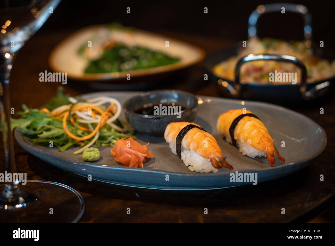 Frisches Nigiri-Sushi, serviert auf einem Teller mit Sojasauce und Gemüse Stockfoto