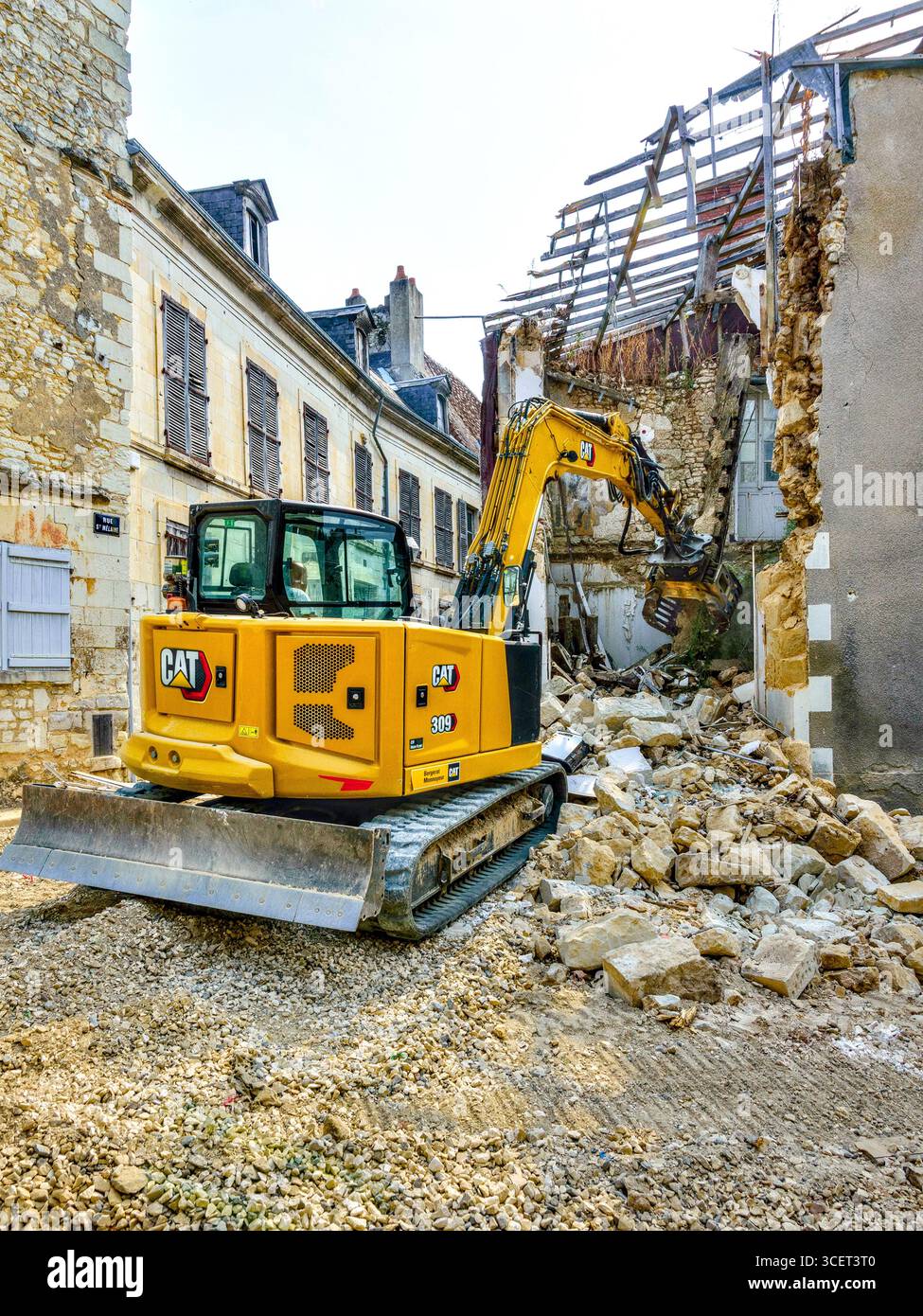 Caterpillar-Hydraulikbagger CAT 309 und CAT 315 bei der Abriss eines alten instabilen Gebäudes an einer stark befahrenen Verkehrsstraße in Preuilly-sur-Claise (37), Frankreich. Stockfoto
