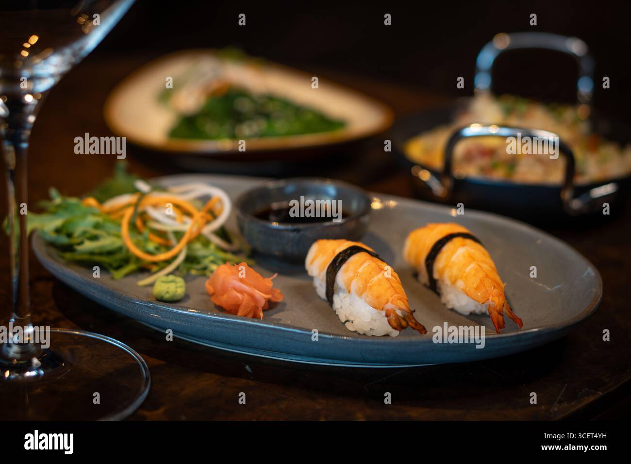 Frisches Nigiri-Sushi, serviert auf einem Teller mit Sojasauce und Gemüse Stockfoto