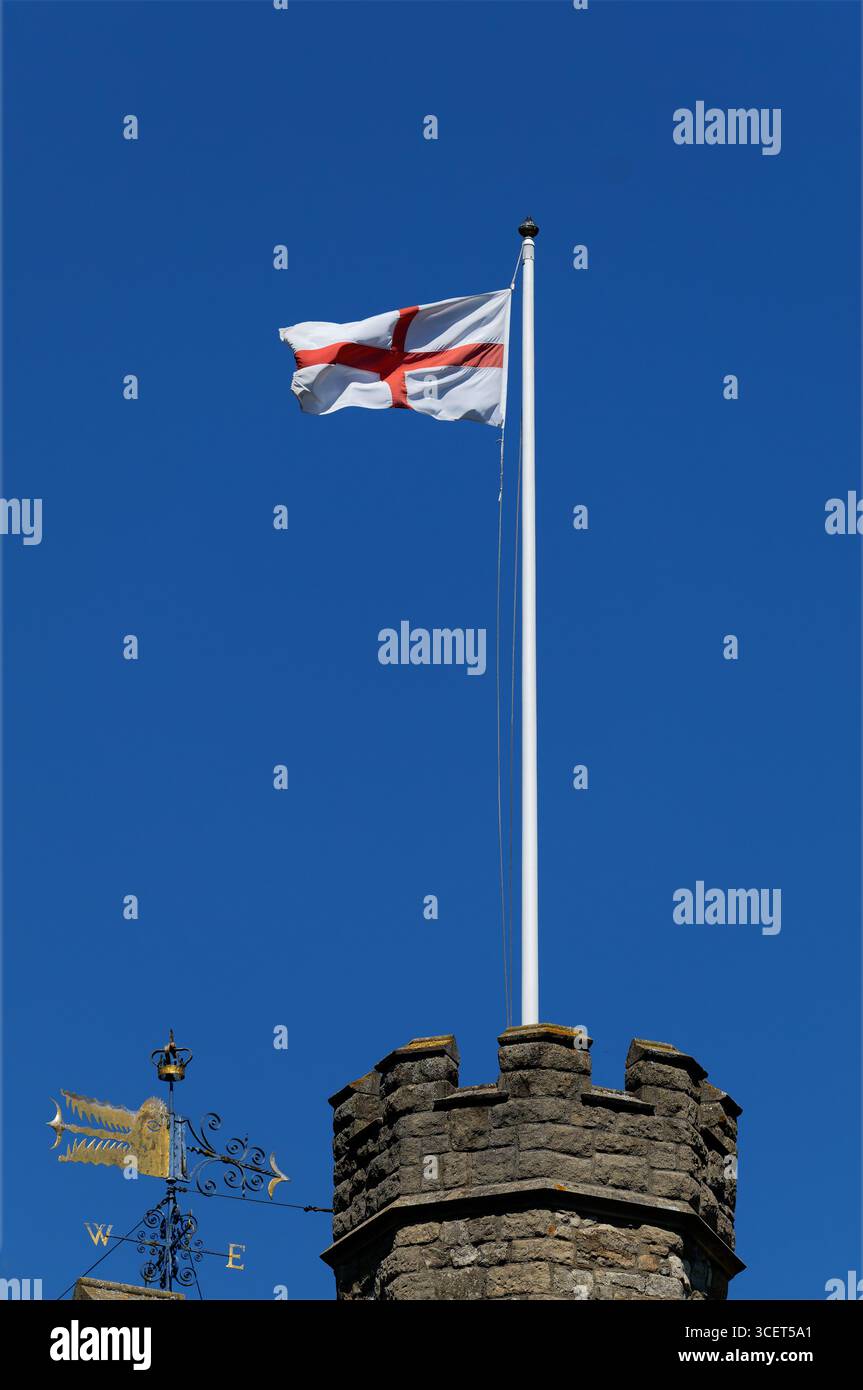 Die Flagge Englands, die auf dem Turm der St. Marys Church in Twickenham, London vor einem klaren blauen Himmel fliegt. Stockfoto